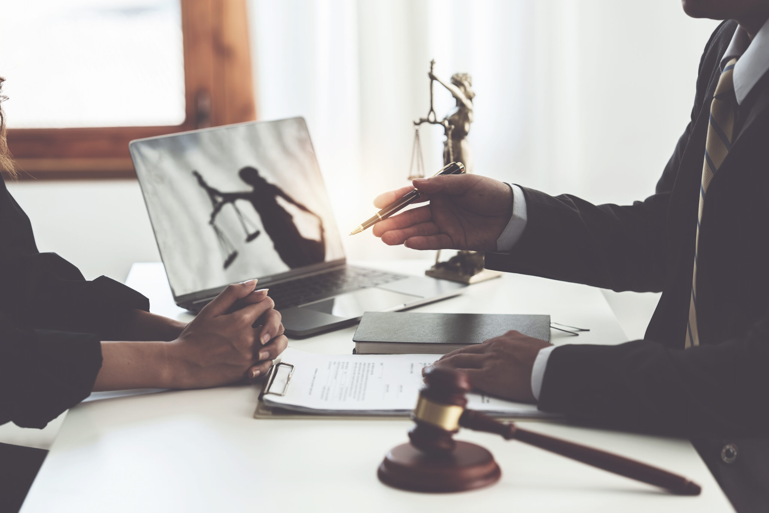Business woman and lawyers discussing contract papers with brass